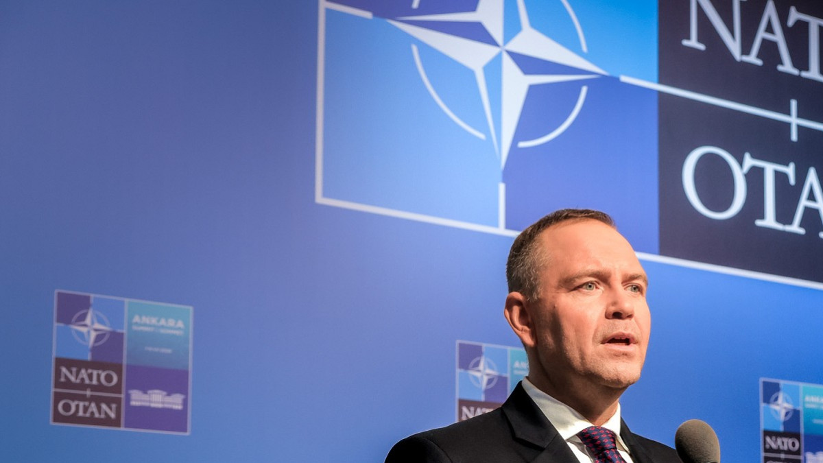 Karol Nawrocki przemawia na tle oznaczeń NATO. Zdjęcie archiwalne.